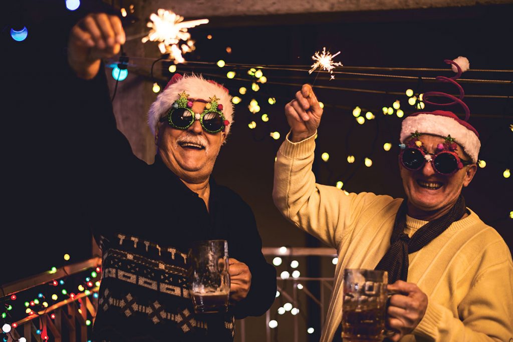 Senior citizen friends holder sparklers celebrating Christmas | Motif
