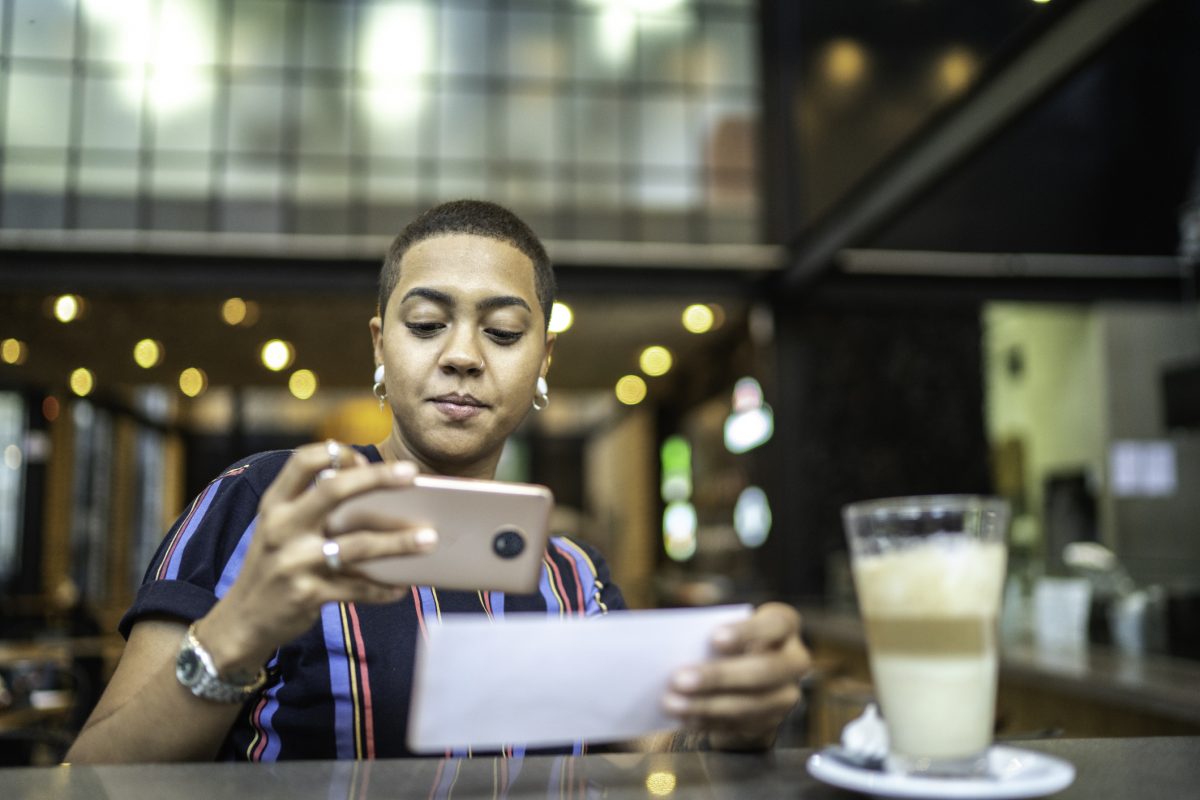photo essay app for iphone Young woman depositing check by phone in the cafe
