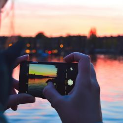 Taking a picture of the sunset over water on an iPhone | Motif