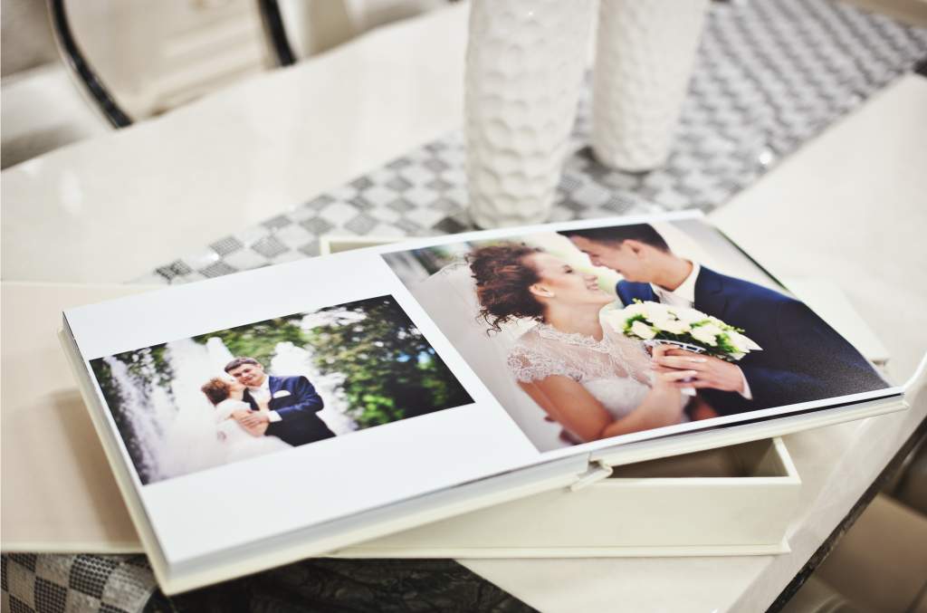 This open wedding album on a white table illustrates the most popular photo book idea.