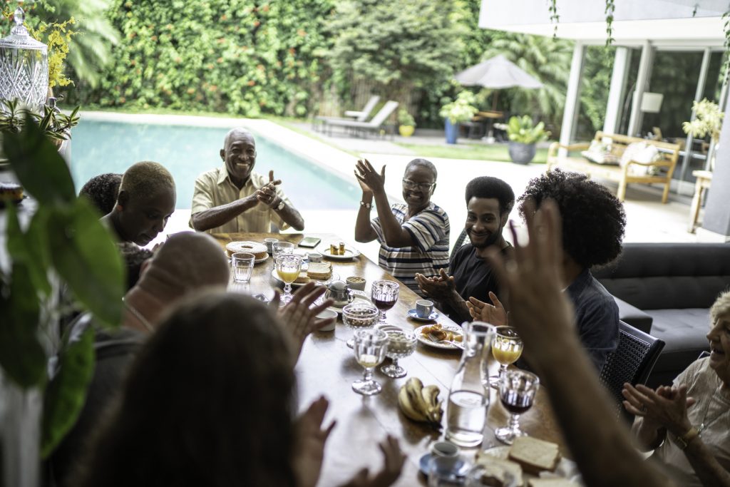 Multigenerational family applauding during breakfast